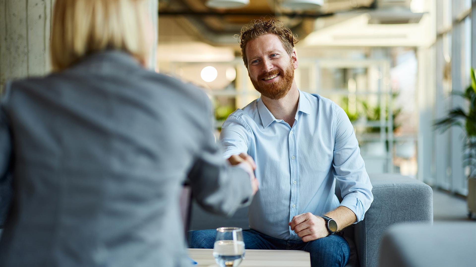Middle aged man shaking hands with his advisor