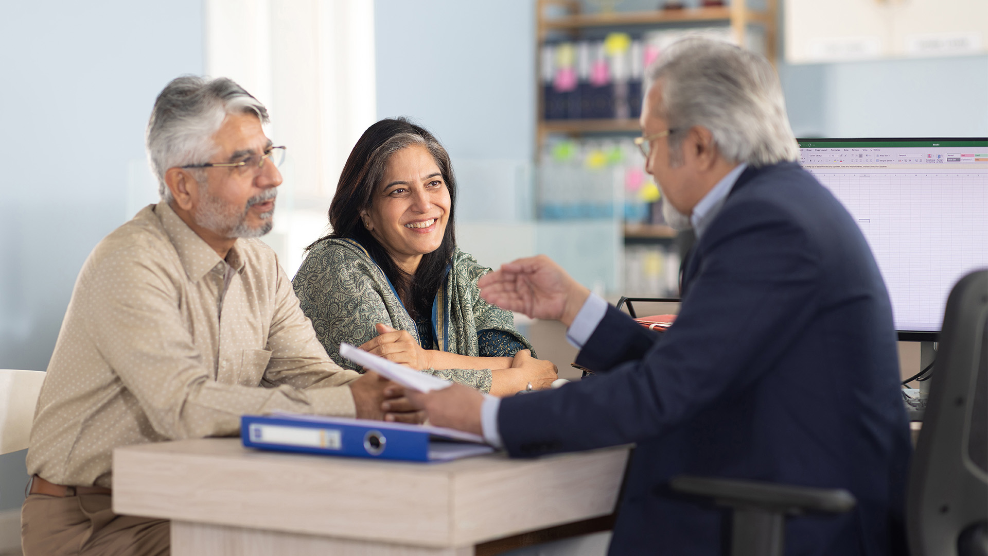 Middle aged male advisor meeting with his retiree clients