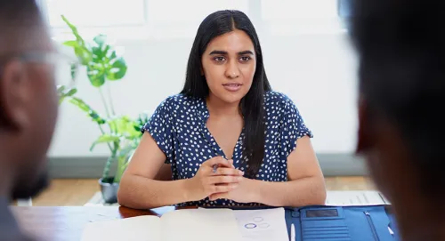Female advisor sitting at her desk speaking with clients