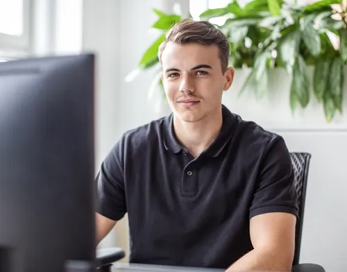 Young male in his 20's studying at his computer