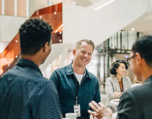 Three coworkers talking together and smiling