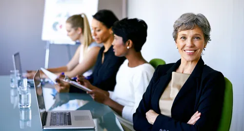 A group of women preparing for a meeting in the conference room