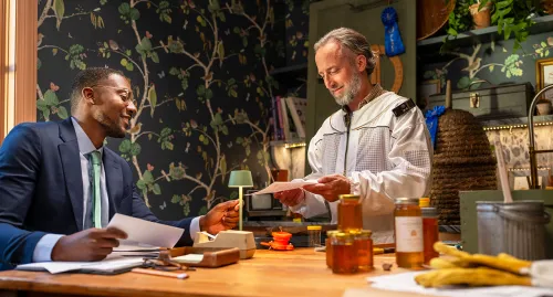 Beekeeper and his financial advisor talking at the table