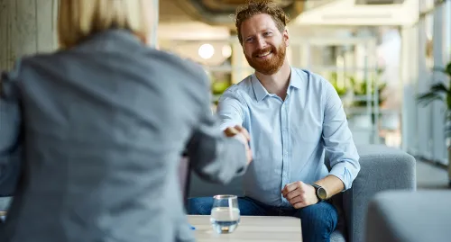 Middle aged man shaking hands with his advisor